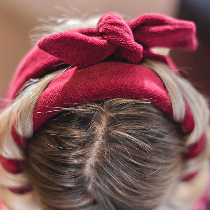 Red velvet heatless hair curler wrapped around blonde hair for gentle curling without heat damage